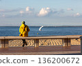 people sitting on a bench looking at the sea 136200672
