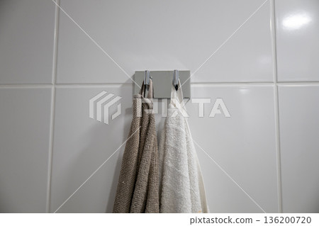 Minimal bathroom towels hanging on wall hook in modern interior Minimal bathroom towels hanging on wall hook in modern interior 136200720
