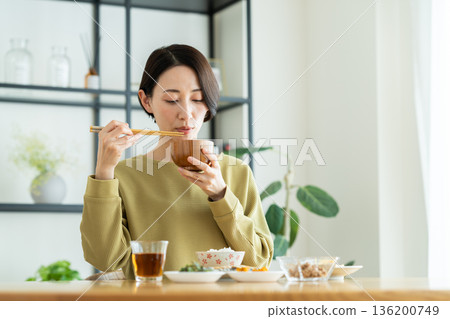 A middle-aged woman drinking miso soup for breakfast 136200749