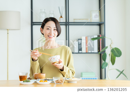 Middle-aged woman eating breakfast 136201205