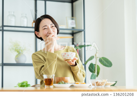 中年婦女正在吃早餐 中年婦女正在吃早餐 136201208