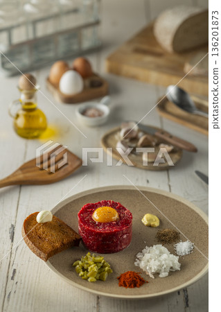 Beef tartare appetizer with raw egg yolk and seasonings Beef tartare appetizer with raw egg yolk and seasonings 136201873