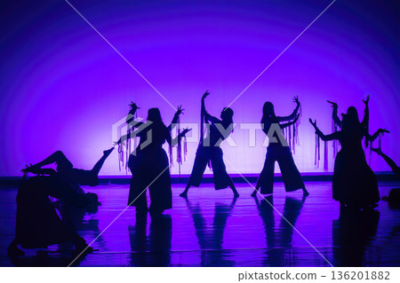 Dancers performing expressive choreography with dramatic purple lighting Dancers performing expressive choreography with dramatic purple lighting 136201882