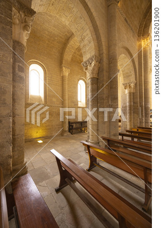 Romanesque church interior with stone arches and wooden pews in Fromista 136201900