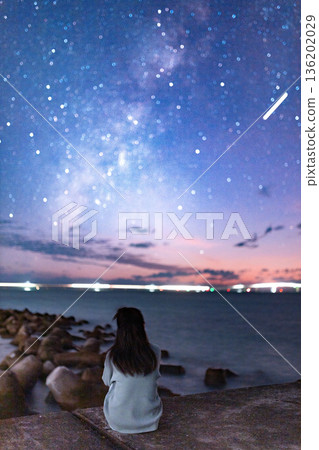 一位女士在海灘上觀賞銀河。 136202029