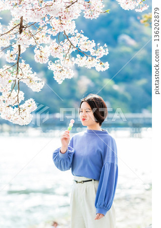 A woman eating dumplings at cherry blossom viewing A woman eating dumplings at cherry blossom viewing 136202879