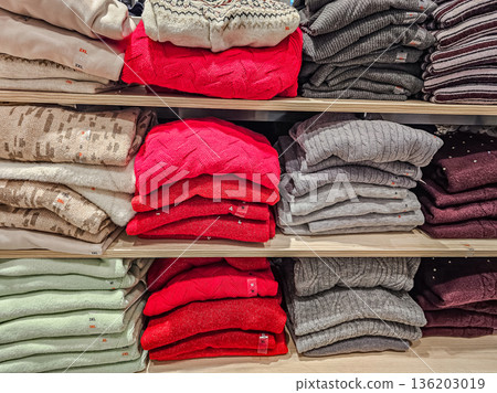 Red and Gray Sweaters Stacked on Shelf 136203019