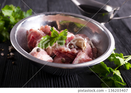 Raw meat, uncooked Meat in a bowl. black background. top view. 136203407