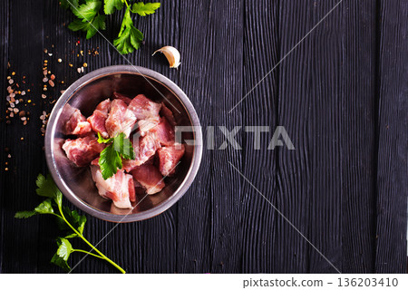 Raw meat, uncooked Meat in a bowl. black background. top view. Raw meat, uncooked Meat in a bowl. black background. top view. 136203410