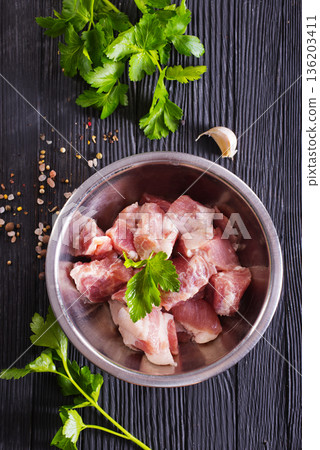 Raw meat, uncooked Meat in a bowl. black background. top view. 136203411