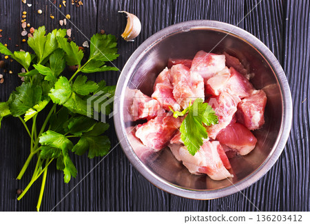 Raw meat, uncooked Meat in a bowl. black background. top view. 136203412