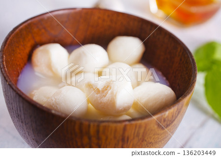 Tasty mozzarella balls and basil leaves in bowl Tasty mozzarella balls and basil leaves in bowl 136203449