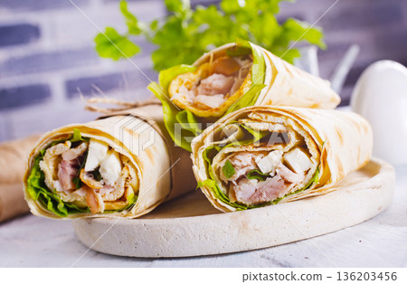 Burrito rolls with ham and cheese on a light background 136203456