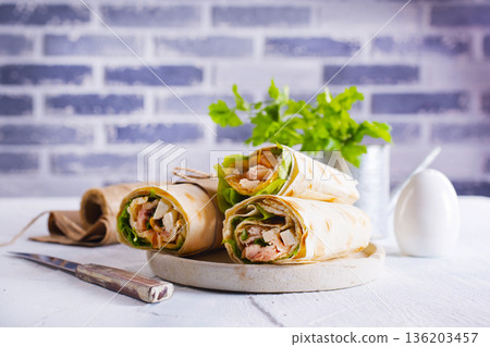 Burrito rolls with ham and cheese on a light background 136203457