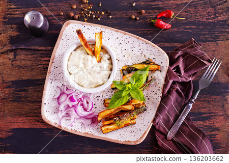 Baked crispy eggplant sticks served with white sauce. Vegetarian healthy dish. 136203662