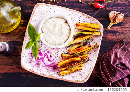 Baked crispy eggplant sticks served with white sauce. Vegetarian healthy dish. Baked crispy eggplant sticks served with white sauce. Vegetarian healthy dish. 136203663