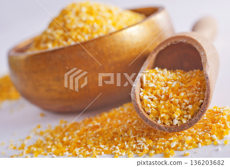Raw cornmeal flour used in polenta, in wooden bowl 136203682
