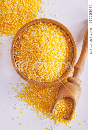 Raw cornmeal flour used in polenta, in wooden bowl Raw cornmeal flour used in polenta, in wooden bowl 136203683