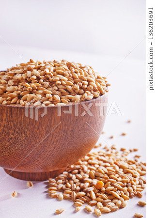 Pearl barley groats in bowl on white table Pearl barley groats in bowl on white table 136203691