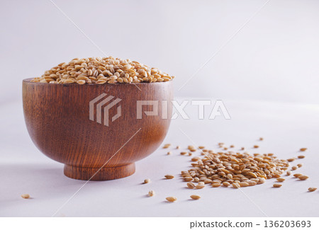 Pearl barley groats in bowl on white table 136203693