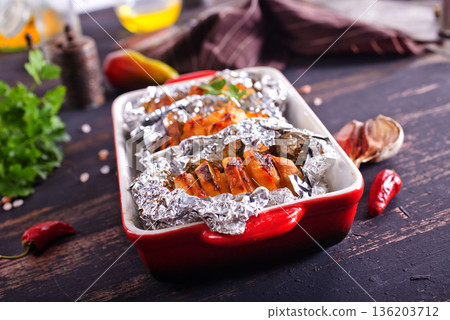 baked potatoes with cheese and bacon served on a baking tray baked potatoes with cheese and bacon served on a baking tray 136203712