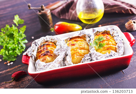 baked potatoes with cheese and bacon served on a baking tray baked potatoes with cheese and bacon served on a baking tray 136203713