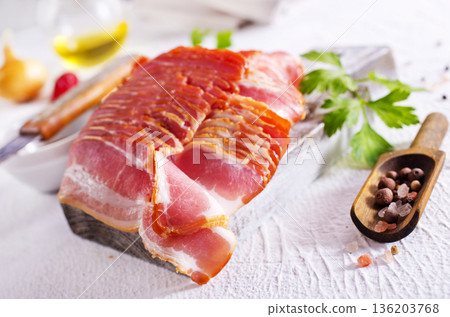 Fresh raw bacon sliced with spices and herbs on a lightr concrete background Fresh raw bacon sliced with spices and herbs on a lightr concrete background 136203768