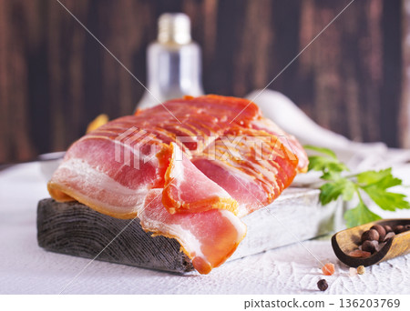 Fresh raw bacon sliced with spices and herbs on a lightr concrete background 136203769