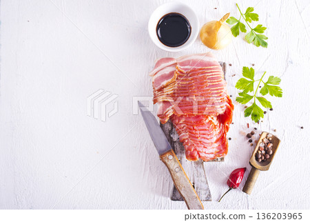 Fresh raw bacon sliced with spices and herbs on a lightr concrete background 136203965
