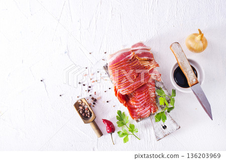 Fresh raw bacon sliced with spices and herbs on a lightr concrete background 136203969