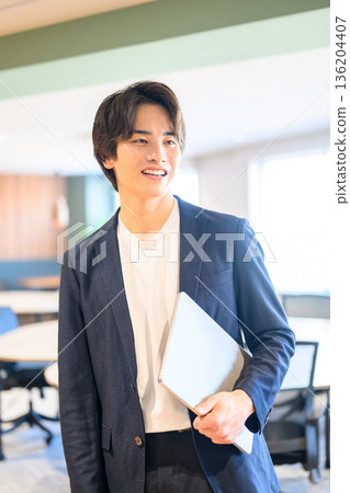 微笑的男子手持筆記型電腦 136204407
