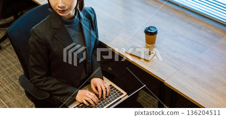 Woman working on a PC 136204511