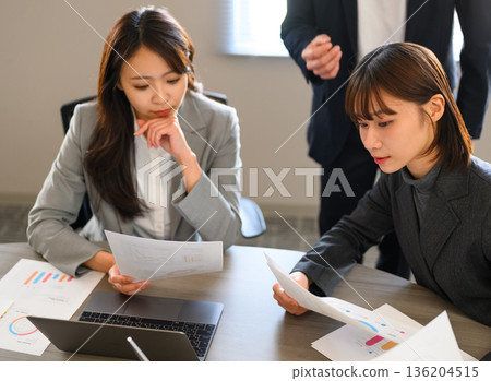 一名女子在會議上檢查文件。 136204515