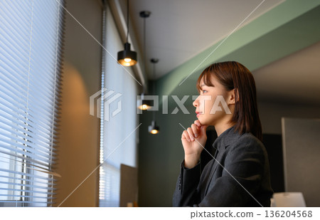 Woman thinking in office Woman thinking in office 136204568
