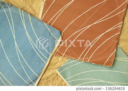 Vintage record cover textures, worn paper album sleeves, curved line patterns in layered composition. Natural background of record cover texture for music industry, retro media, audio archive design 136204658