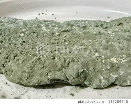A close-up shot of moldy bread. Baked goods covered in blue mold due to long-term and improper storage. 136204846