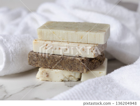 Unbranded beige and brown solid soap bars on white terry towel, bathroom spa amenities Unbranded beige and brown solid soap bars on white terry towel, bathroom spa amenities 136204948