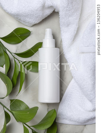 Mockup of blank white spray bottle near white bath terry towel and green leaves. Unbranded cosmetic Mockup of blank white spray bottle near white bath terry towel and green leaves. Unbranded cosmetic 136204953