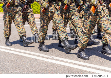 Military personnel marching in formation on paved road 136205001