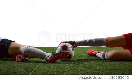 Close up of soccer players legs fighting for ball on white background. 136205045
