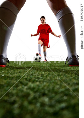 Female soccer player dribbling ball while opponent blocks path on white background. 136205047