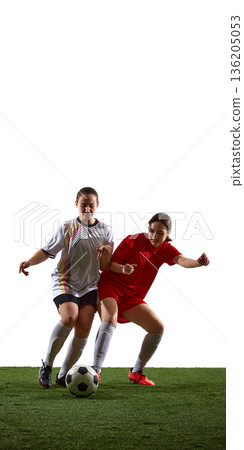 Two female soccer players competing for ball on white background. 136205053