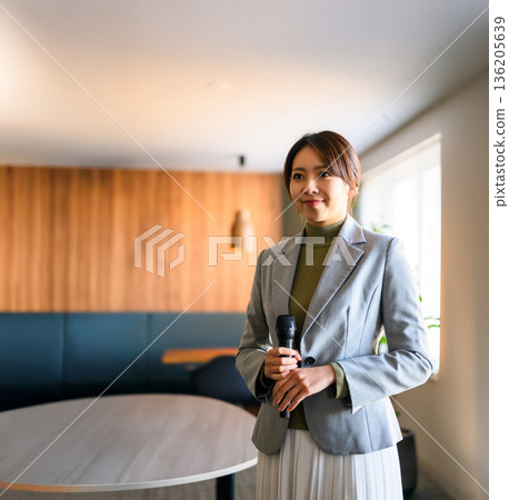 A woman holds a microphone 136205639