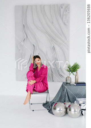 Relaxed Woman In Pink Outfit Sitting Indoors Relaxed Woman In Pink Outfit Sitting Indoors 136205686