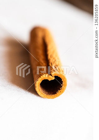 Cinnamon cassia sticks stacked together, showcasing their rich brown color and curled ends. Ideal for culinary and aromatic uses. 136205859