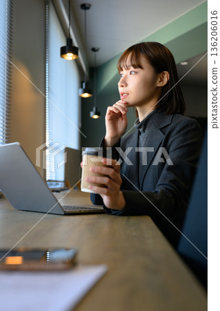Businesswoman thinking in a cafe Businesswoman thinking in a cafe 136206016