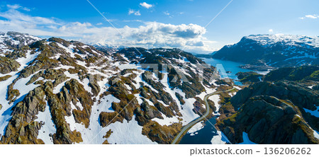 Mountain landscape in summer. Aerial view at glacier melted lake, mountains ridge, and highway. Nature park in Sauda municipality, Rogaland fylke. Beautiful nature of Norway. Horizontal banner 136206262