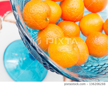 Tangerines in a blue vase. 136206288