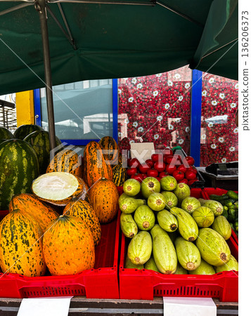 Rows of fresh fruits and vegetables in boxes in local market. Watermelon, melon, squash for sale. 136206373