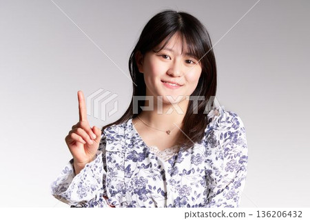 A smiling Japanese woman showing off her number one status 136206432